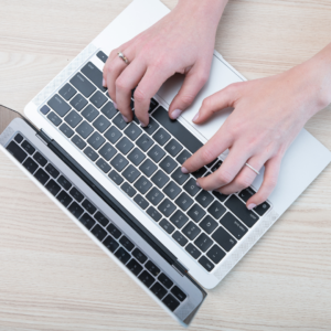 hands typing on laptop keyboard