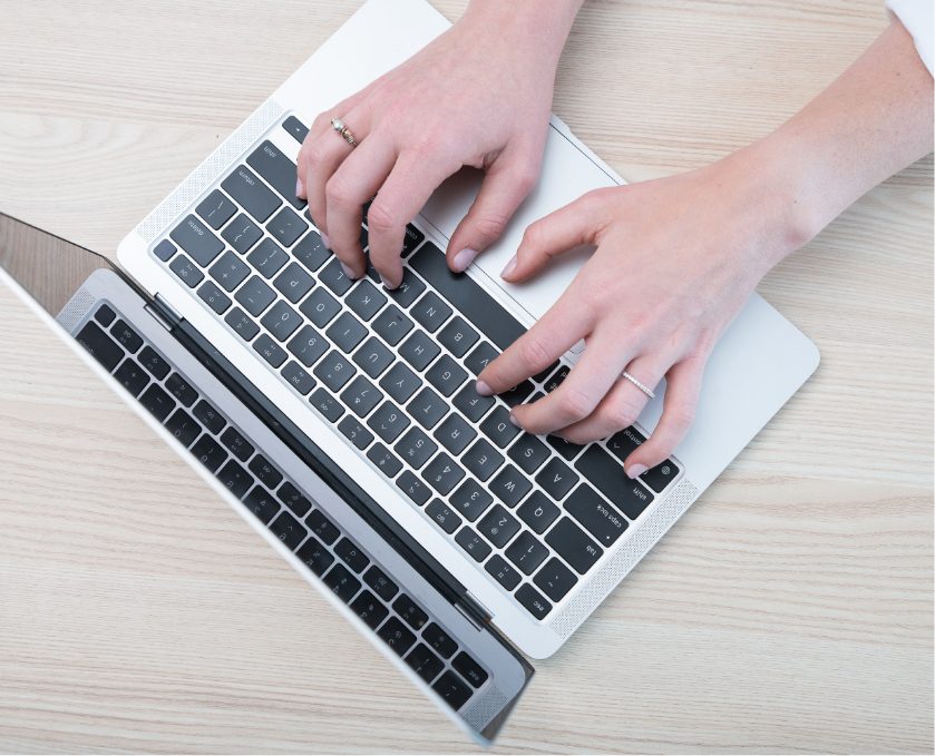 Hands on a laptop computer exploring the Ascent Blog